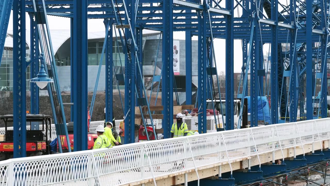 Crew building a truss bridge